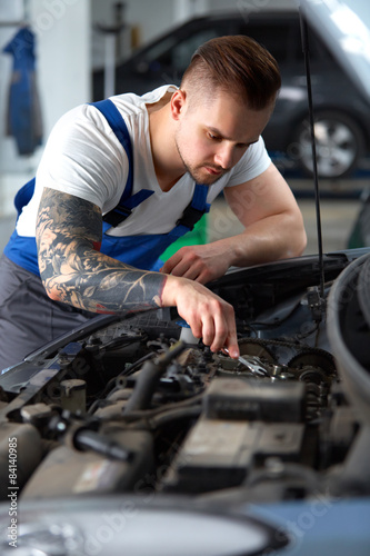 Car Mechanic Working With Engine. Auto Repair Shop
