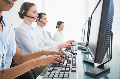 Business people with headsets using computers 