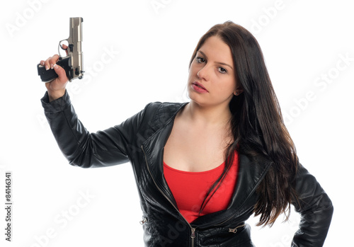 Obraz na plátně Junge Frau in Lederjacke hält eine Waffe