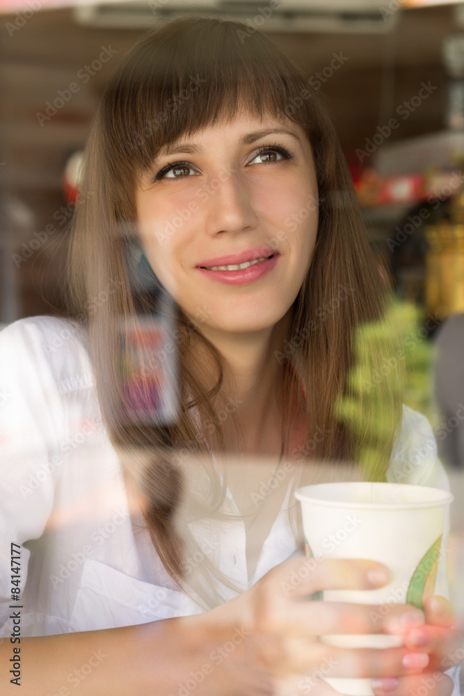 Smiling young woman at the cafe with cup of coffee or tea Smiling young woman at the cafe with cup of coffee or tea