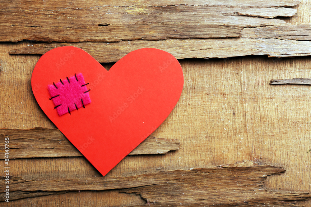 Patch on broken heart on wooden background Patch on broken heart on wooden background