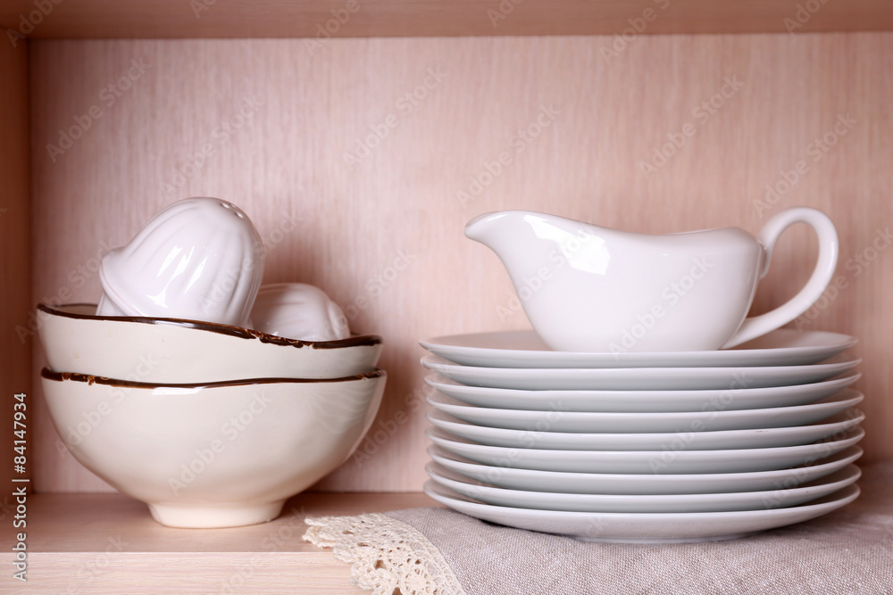 Kitchen utensils and tableware on wooden shelf Kitchen utensils and tableware on wooden shelf