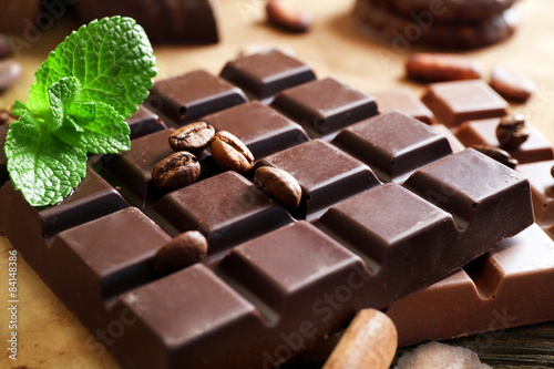 Chocolate with mint, spices and coffee beans on table, closeup