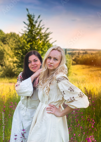 Two ukrainian girls in national costumes at the meadow photo