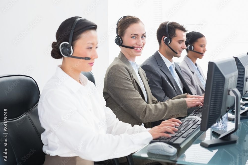 Business people with headsets using computers Business people with headsets using computers