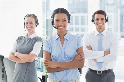 Business people with headsets smiling at camera 