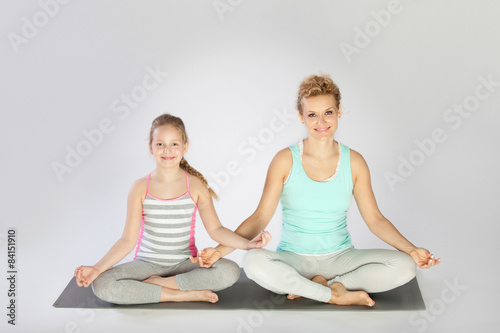 Mother and daughter doing yoga exercise