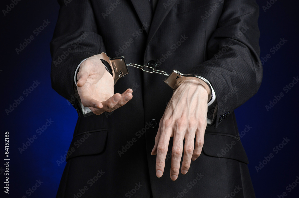 businessman in a black suit with handcuffs on his hands studio businessman in a black suit with handcuffs on his hands studio
