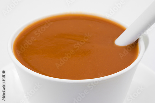 Tomato soup in a cup with spoon