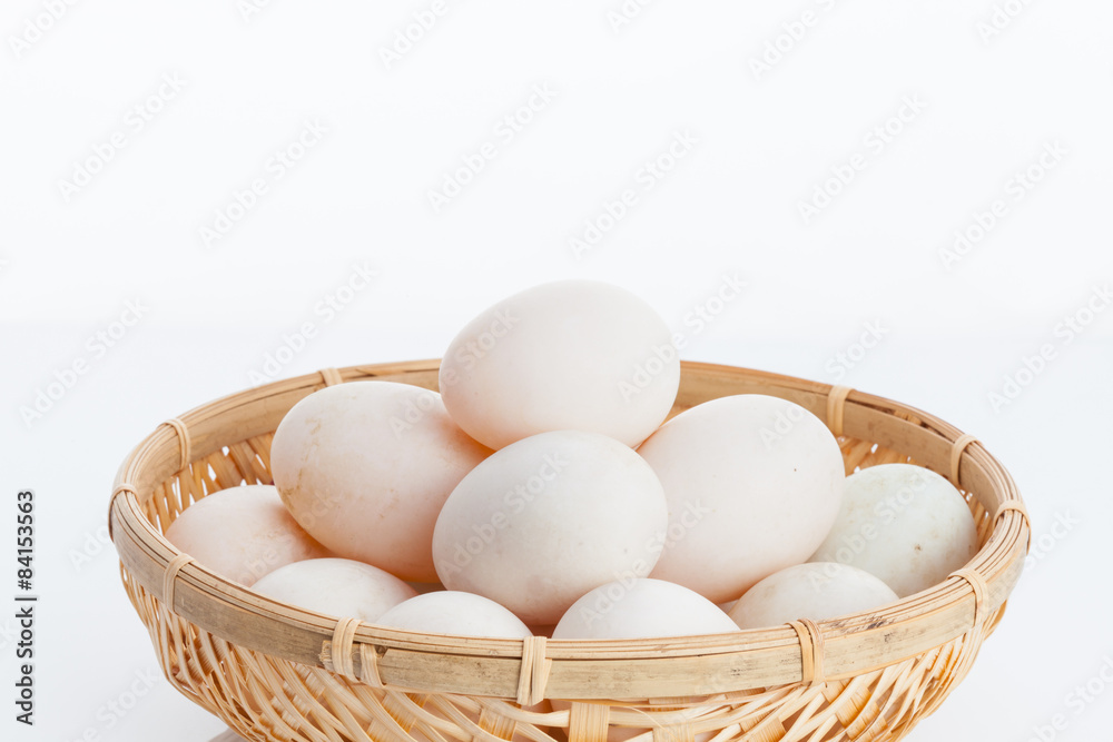 Raw dirty duck eggs in the bamboo bowl basket on white backgroun