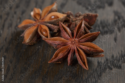 anise stars on old oak table close up photo