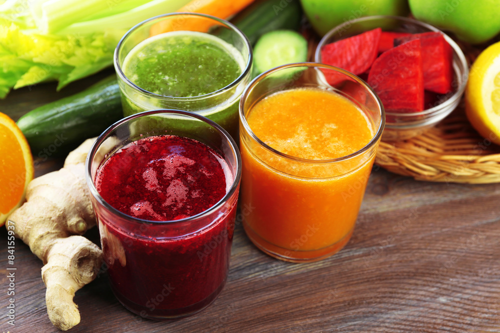 Assortment of healthy fresh juices on wooden table background Assortment of healthy fresh juices on wooden table background