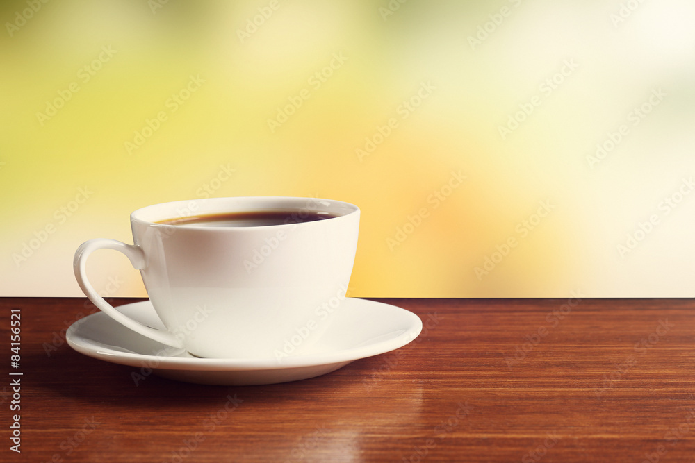 Cup of coffee on table on bright background Cup of coffee on table on bright background