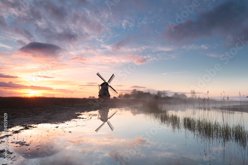 windmill by river in morning mist