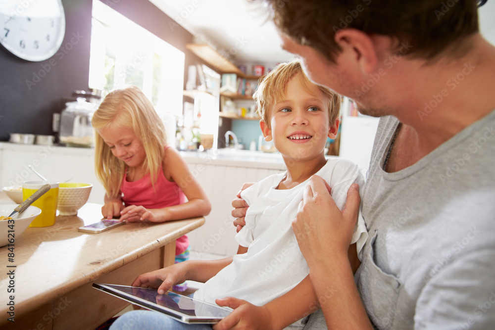 Father And Children Using Digital Devices At Breakfast Table Father And Children Using Digital Devices At Breakfast Table