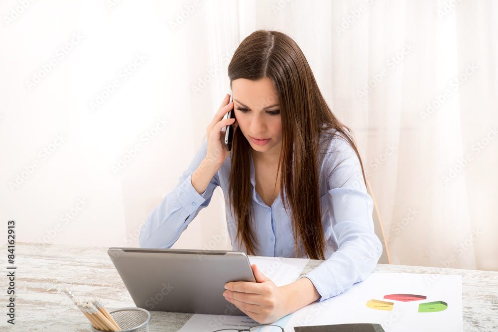 Working at the office with the tablet and talking by phone Working at the office with the tablet and talking by phone