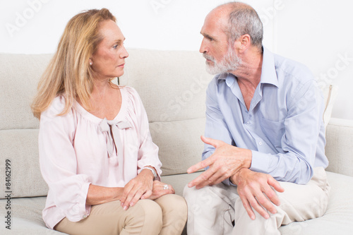 Two seniors talking while sitting on a coach