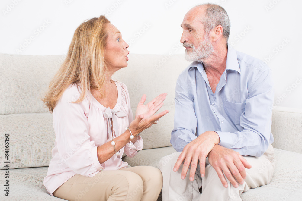 Obraz premium Two seniors talking while sitting on a coach