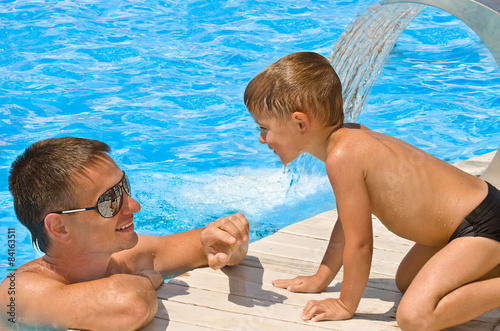 Father and son resting at the pool