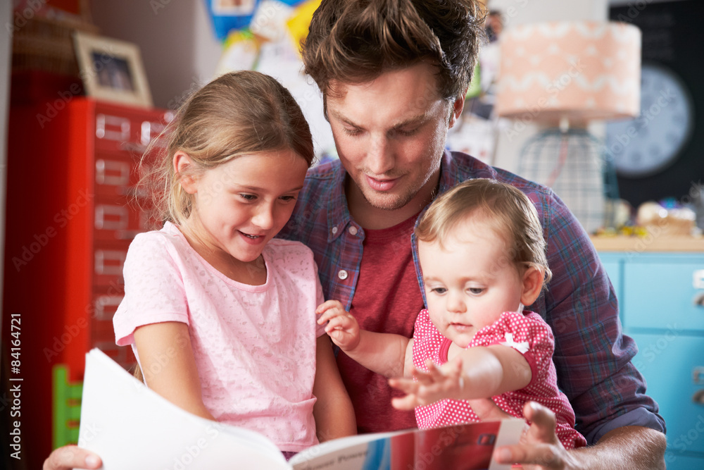 Father Reading Book With Daughters In Bedroom Father Reading Book With Daughters In Bedroom