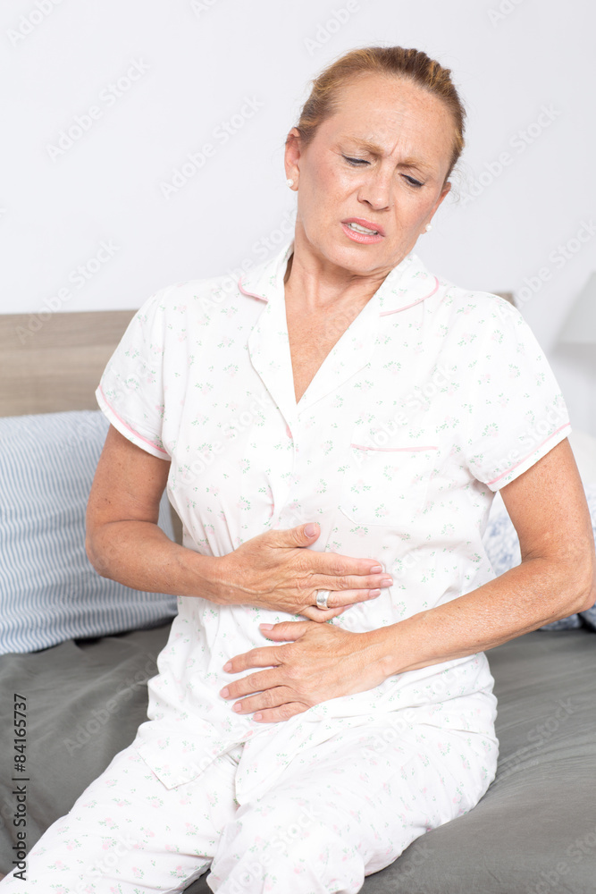 Seniorin im Bett mit Bauchschmerzen Seniorin im Bett mit Bauchschmerzen