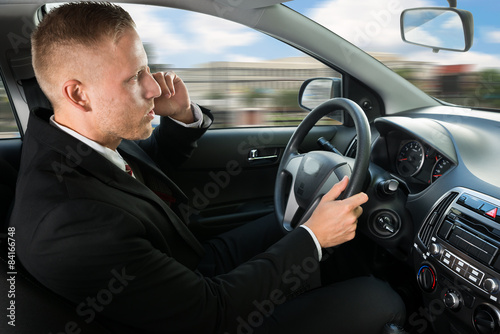 Man Using Cellphone While Driving © Andrey Popov