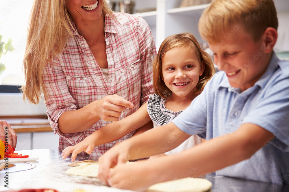 Mother preparing pizza with kids