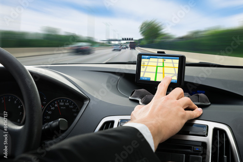 Person's Hand Using Gps Navigation System In Car