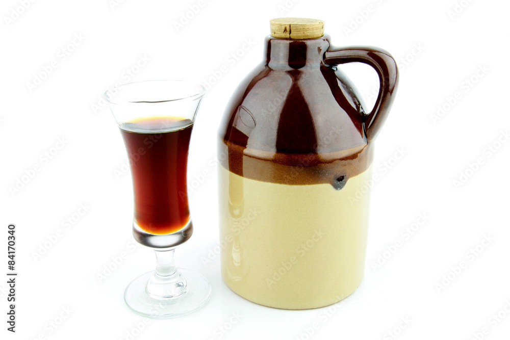Old clay jug with a cork used to hold booze, with a filled glass next to it. Old clay jug with a cork used to hold booze, with a filled glass next to it.