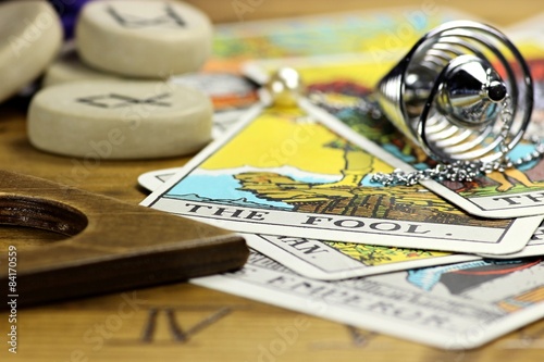 Tarotkarte THE FOOL mit Pendel und Runensteinen auf Ouija photo