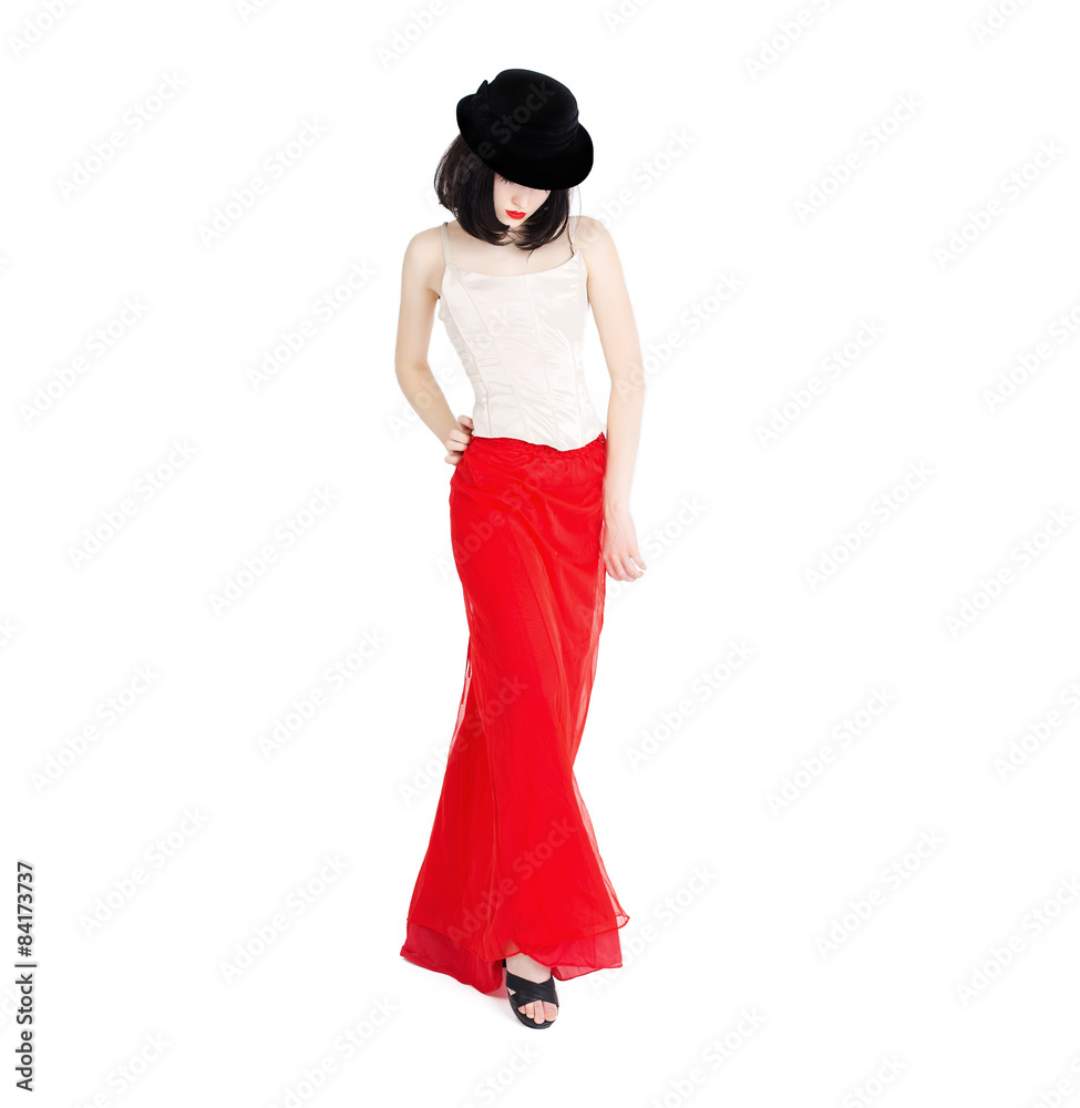 Portrait of beautiful fashion woman in black hat with red lips and red long skirt walking on a white background isolated