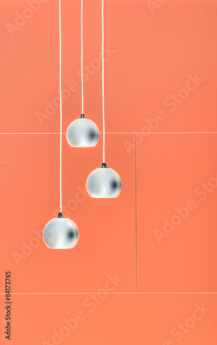 Orange negative collage of three ceiling lights, loft-style inte