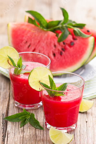 Two glasses with watermelon smoothies with lime and mint