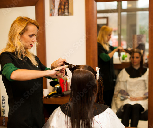 Hairdresser making hair treatment to a customer in salon