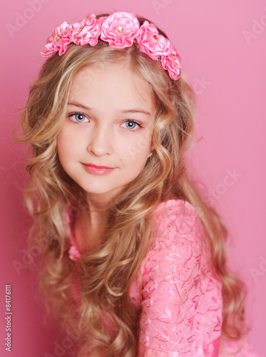Cute kid girl 10 years old posing over pink