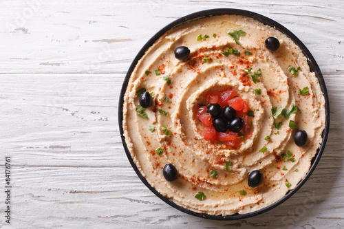 Fresh hummus with olives and tomatoes. horizontal top view
