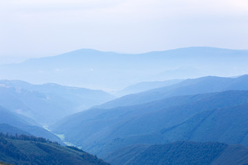 Fotobehang Heuvel Blauwe heuvels in nevelig landschap  © Sergii Mostovyi