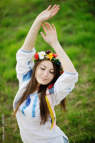 Ukrainian girl in a shirt and a floral wreath on her head pullin