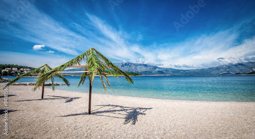 Palm umbrellas on beach in Croatia photo