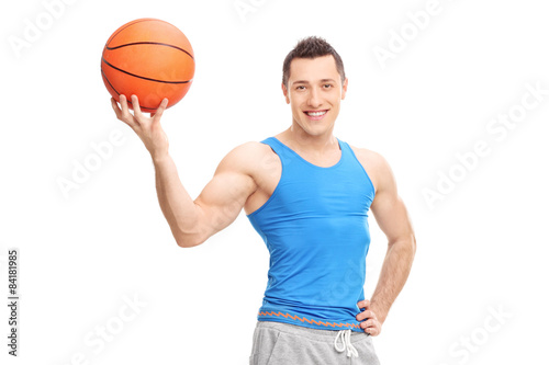 Handsome young man posing with a basketball in his hand