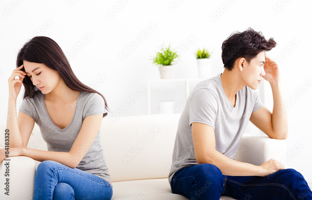 young Couple not talking after fight in living room young Couple not talking after fight in living room