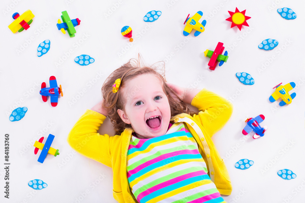 Little girl playing with wooden airplane