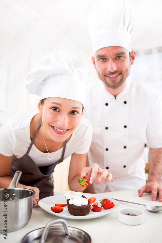 Young chef training a young attractive girl to cook Young chef training a young attractive girl to cook