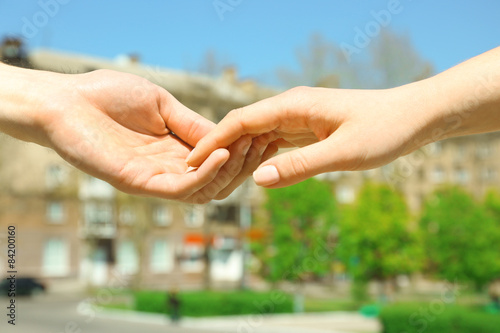 Couple holding hands on blurred background © Africa Studio