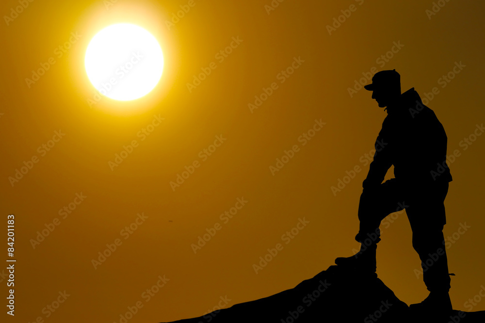 Silhouette of soldier with rifle against a sunset