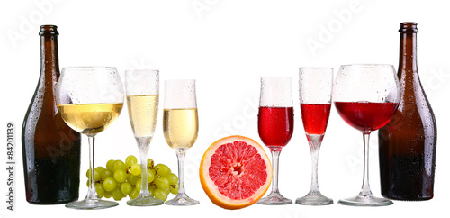 bottle, a row of white wine glasses with wine and grapes isolate