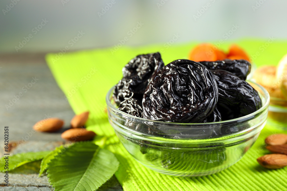 Dried fruits and almonds with leaves on green napkin, closeup Dried fruits and almonds with leaves on green napkin, closeup