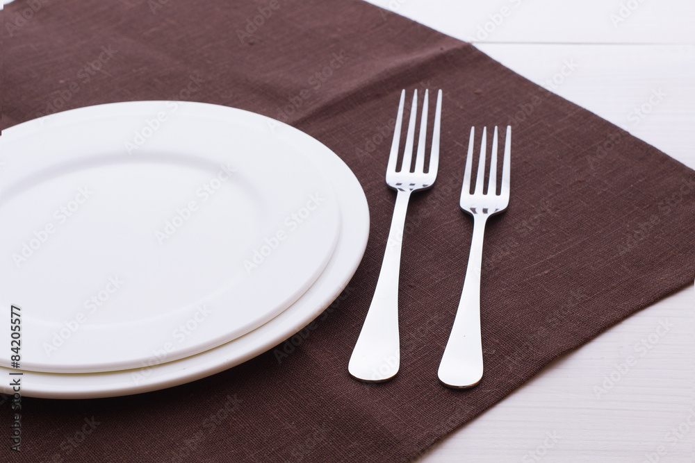 Empty plates and cutlery tablecloth on wooden table for dinner. Empty plates and cutlery tablecloth on wooden table for dinner.