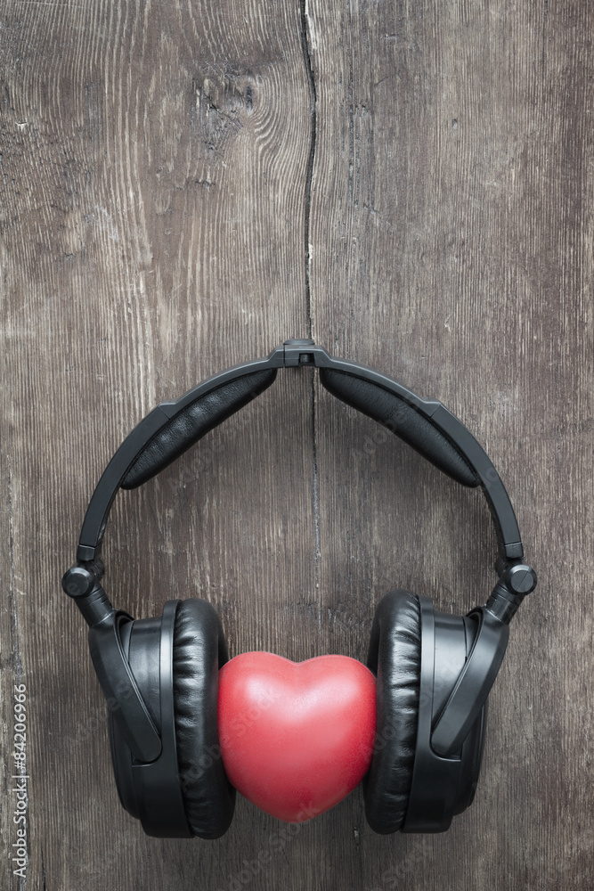 black headphones with red heart on rustic wooden background black headphones with red heart on rustic wooden background