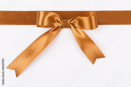 Gold bow on a satin ribbon on a white background